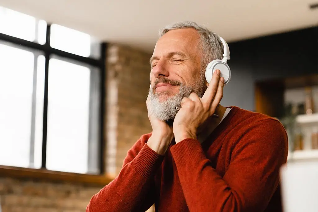 Bearded middle-aged man listening to music