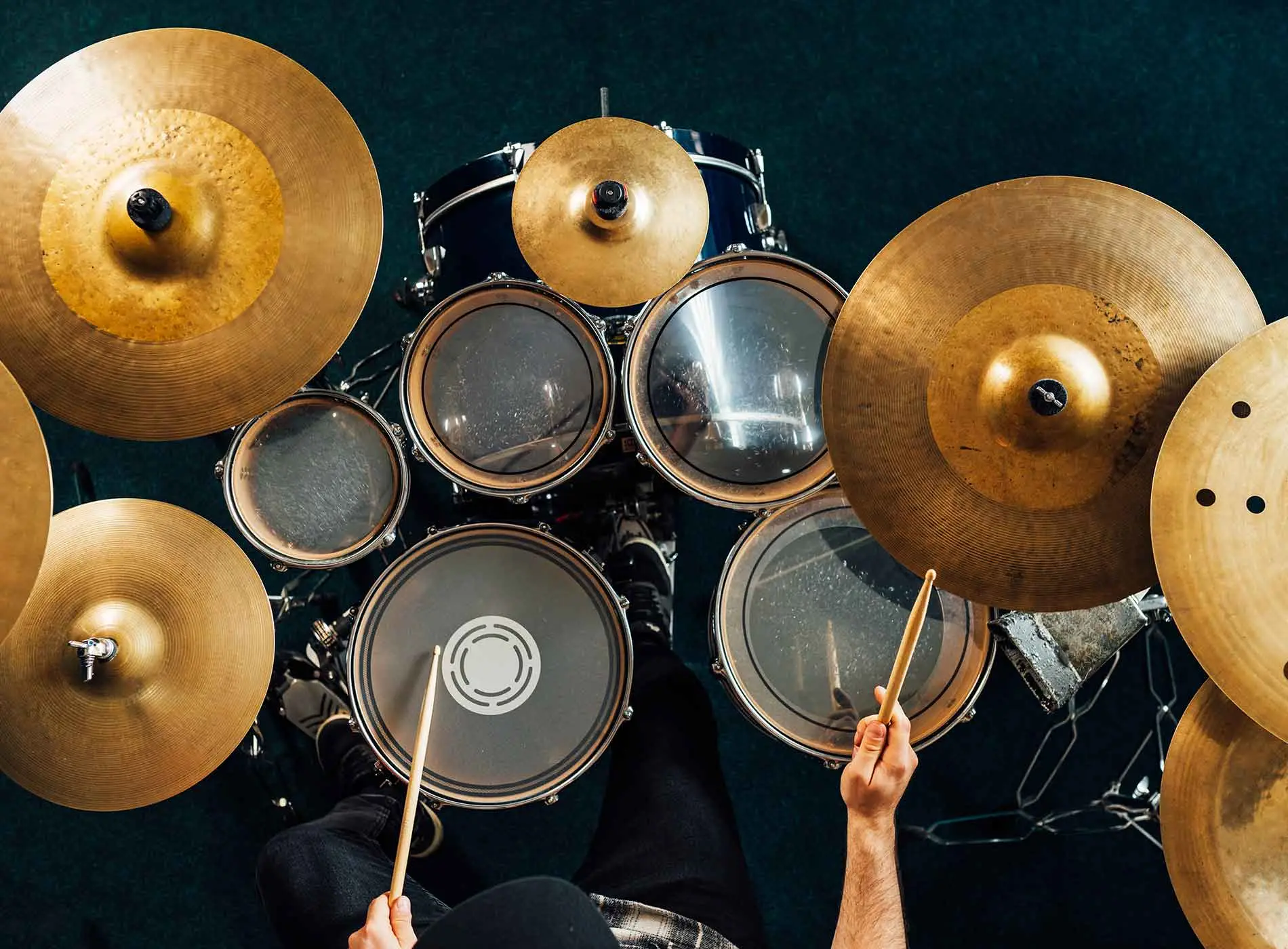 Drummer playing complete drum kit top view