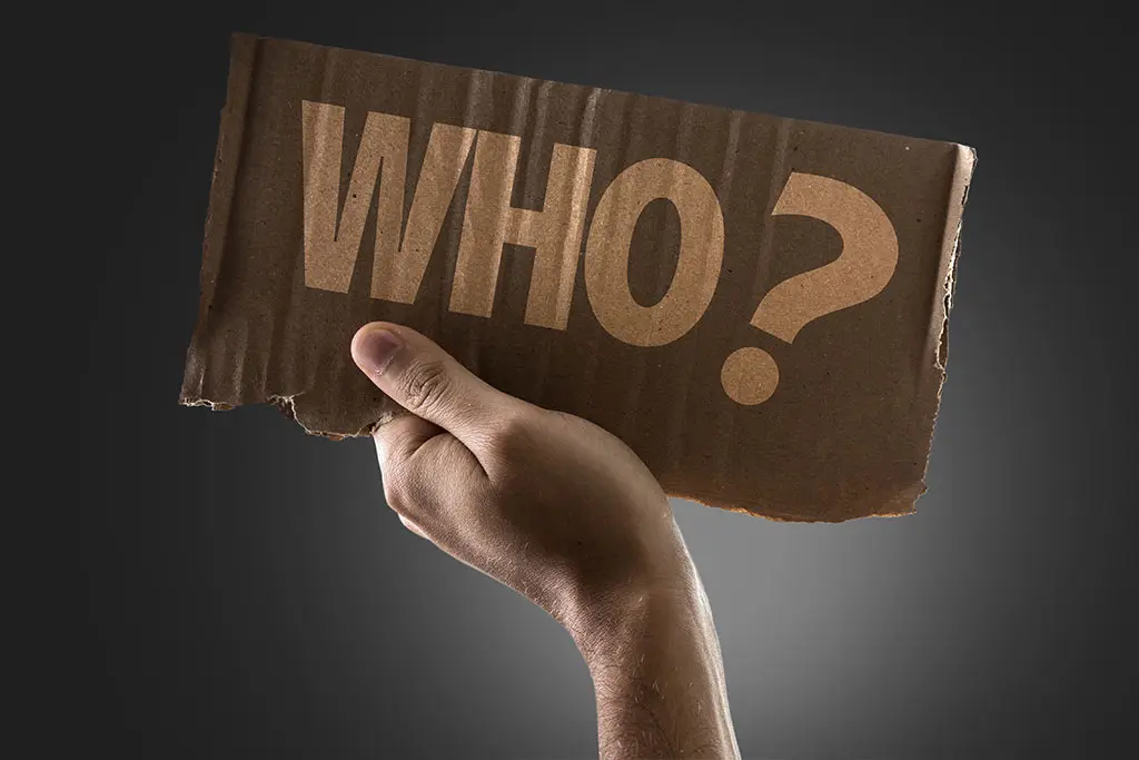 Hand holding a card board with who writing