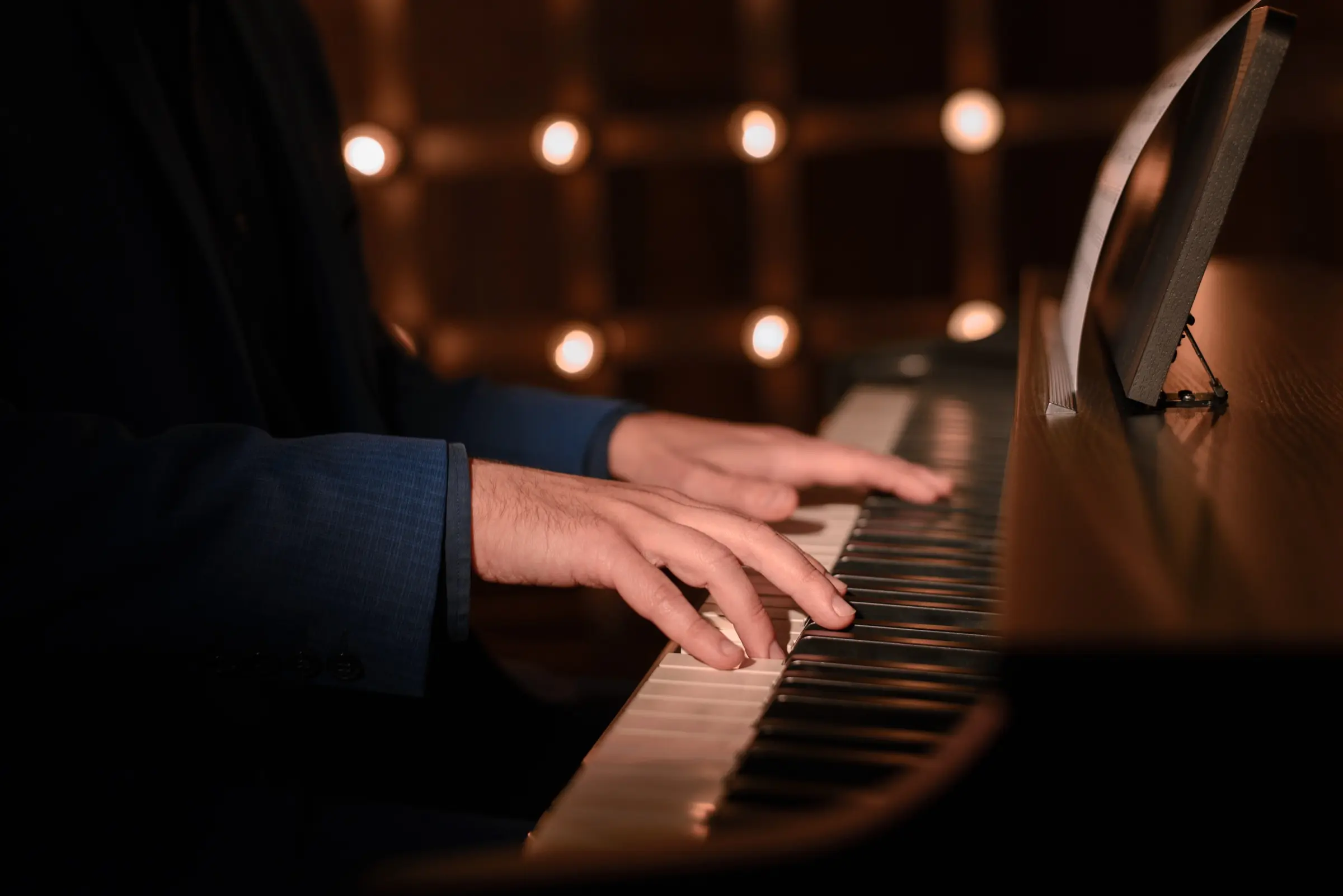 Close-up of hands playing the keys of a piano.
