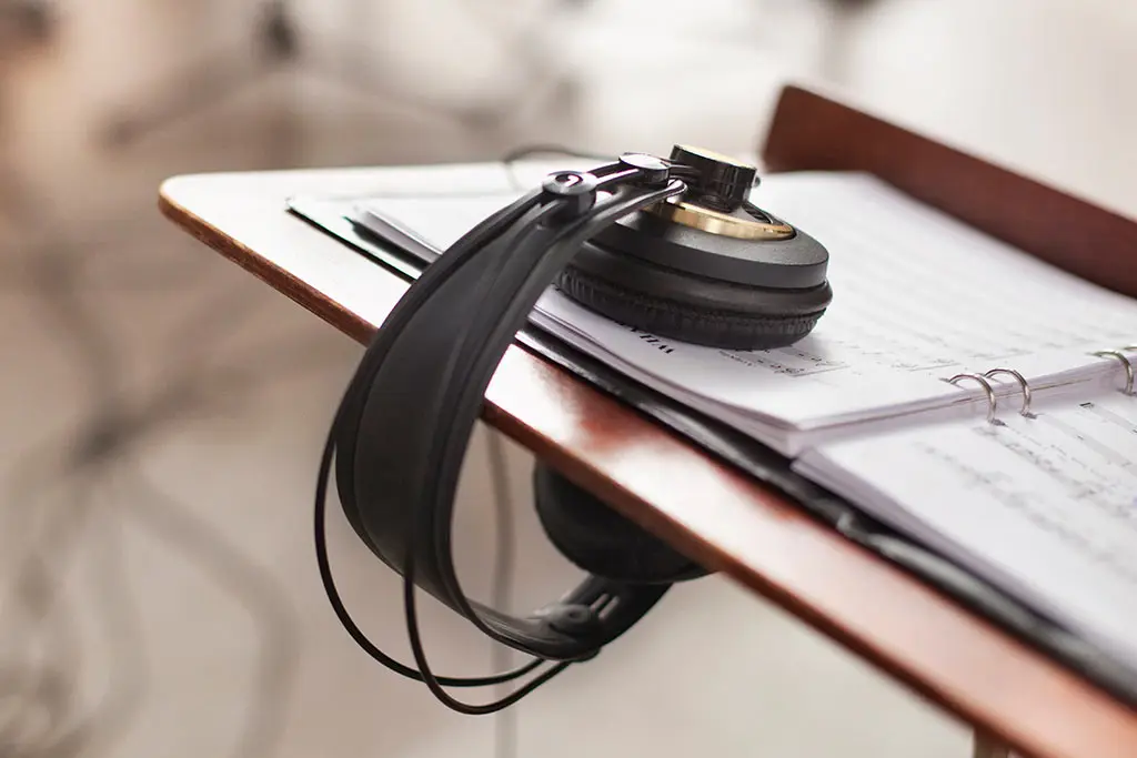 Headphones resting on sheet music on a stand