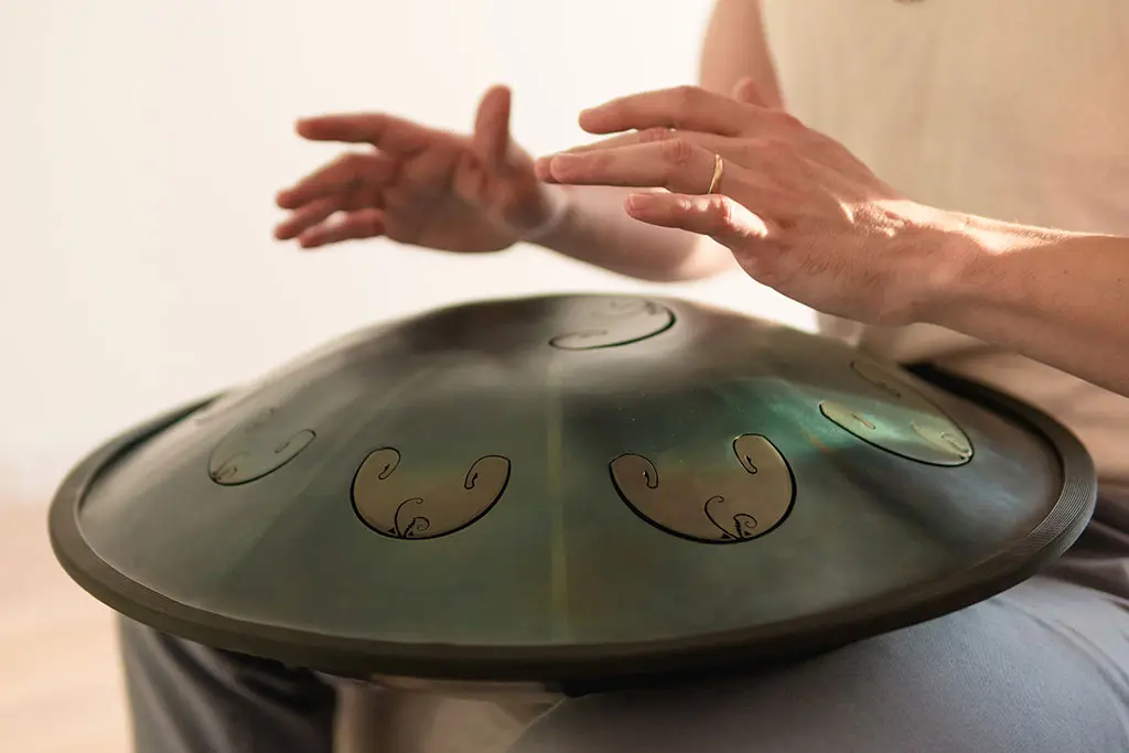 Man hands playing hang drum