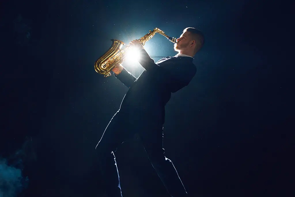 Man playing saxophone with spotlight