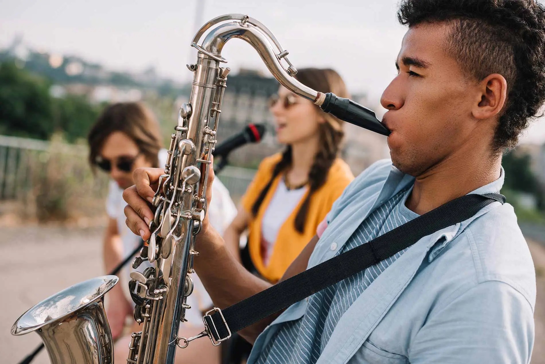 Man playing saxophone with his friends in a band