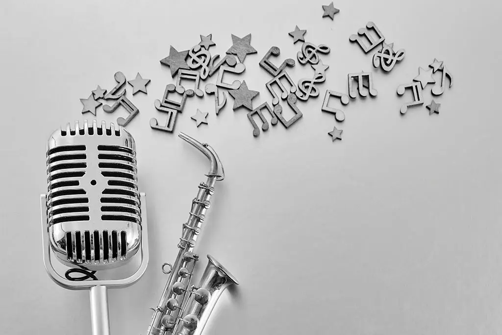 Microphone and saxophone beside scattered music symbols