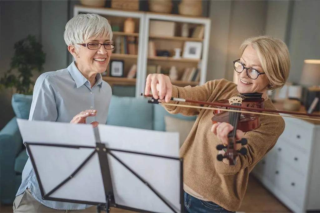 Middle aged violin teacher and student having lesson