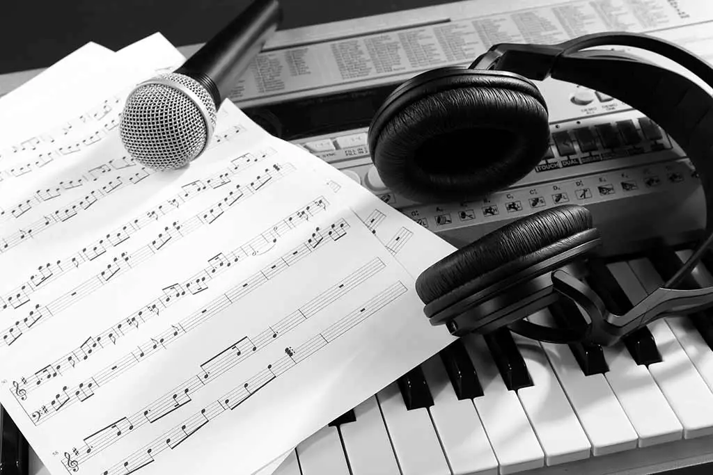 Music sheet microphone and headphones on piano