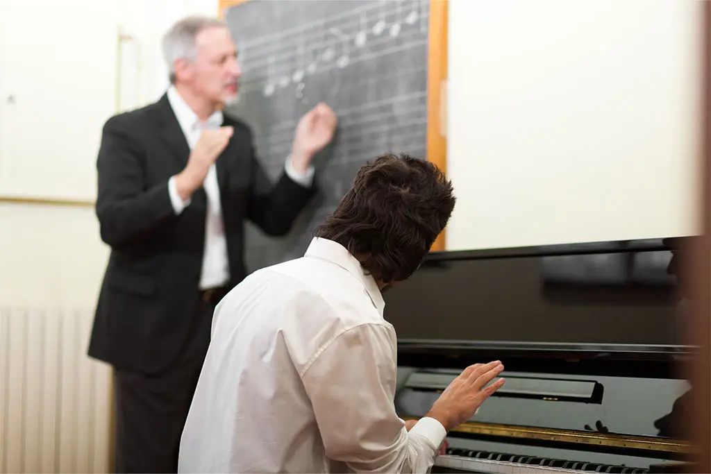 Music teacher and student having piano lesson