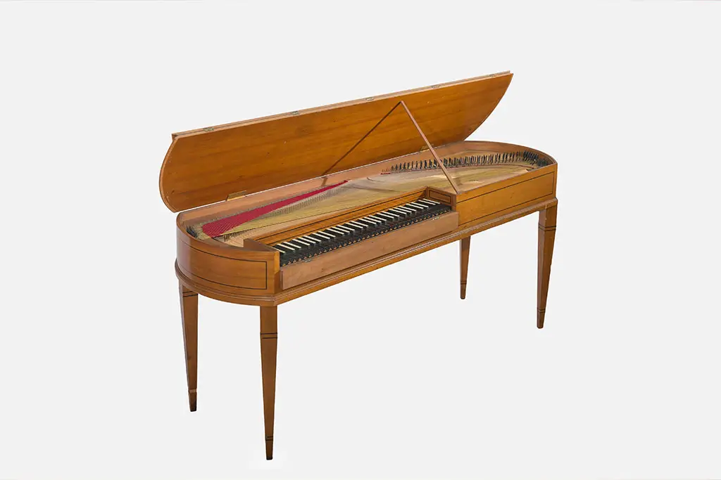 Open wooden harpsichord with visible strings and keyboard