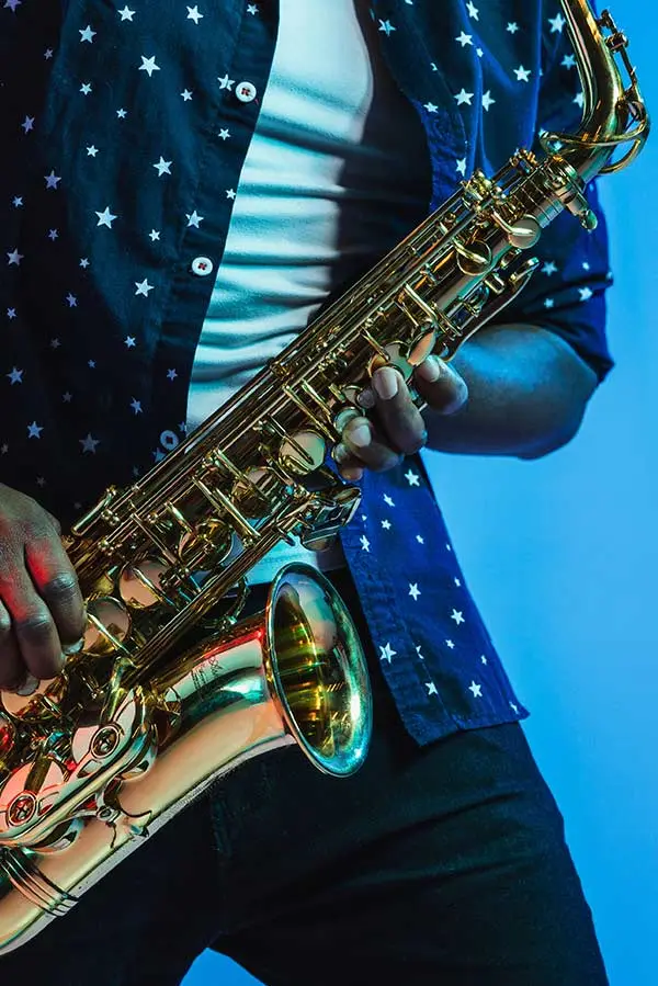Person in a star-patterned shirt holding a saxophone