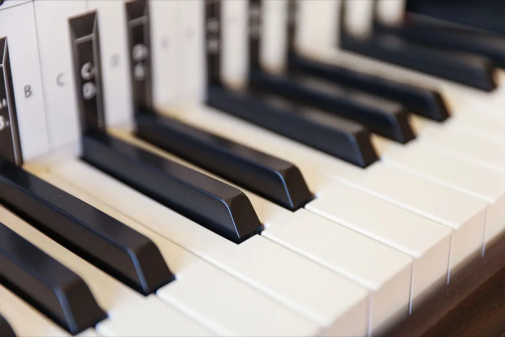 Close-up of piano keys with small letter labels