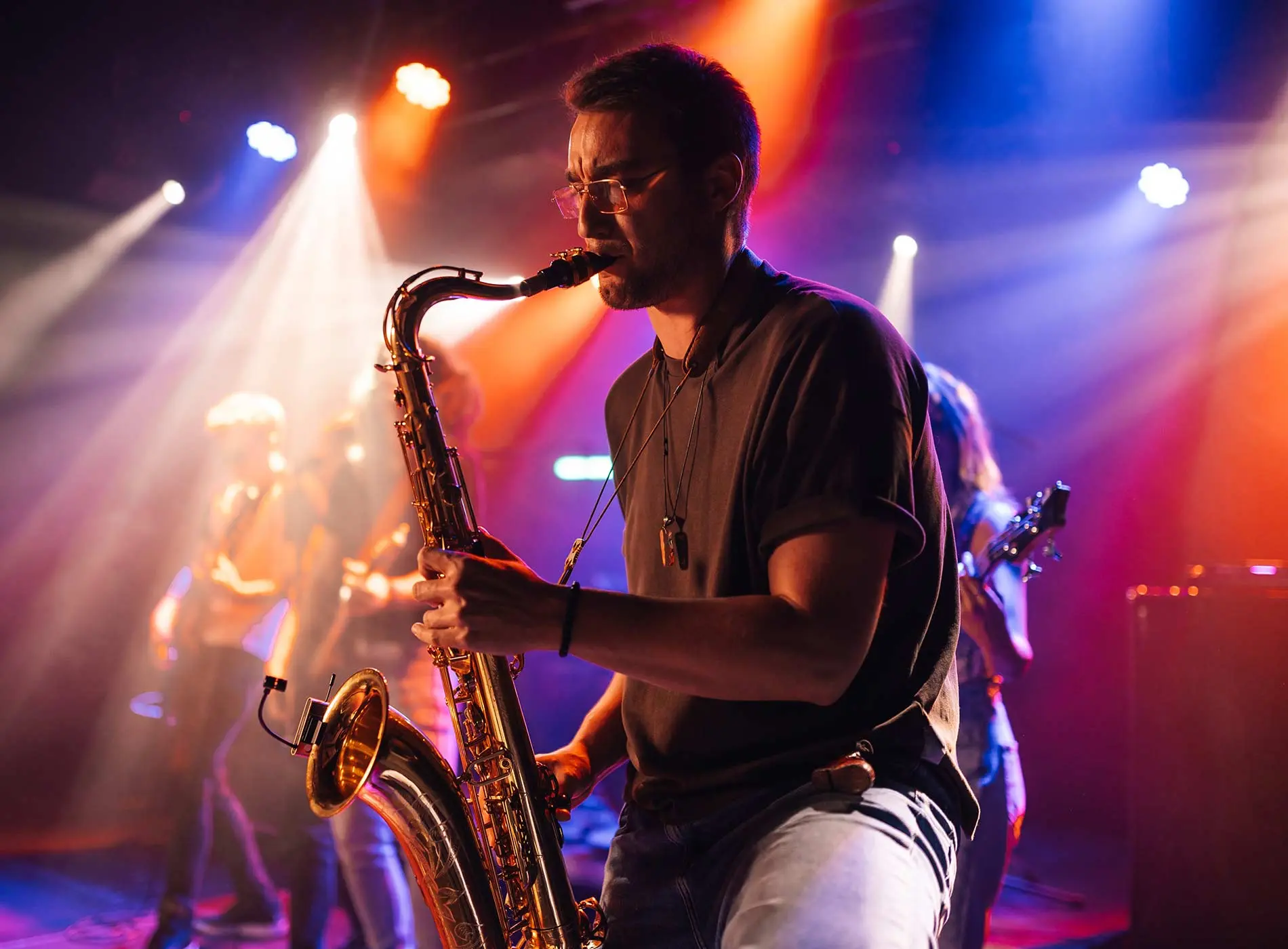 Male saxophonist playing saxophone during live performance on stage