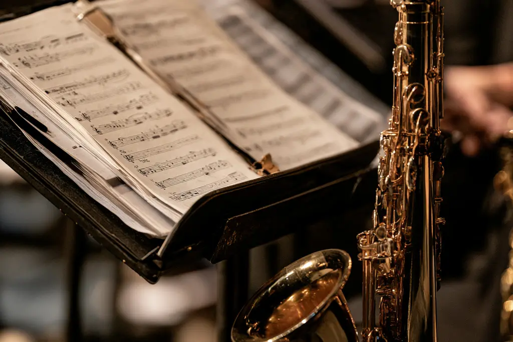 Sheet music open on a stand beside a saxophone.