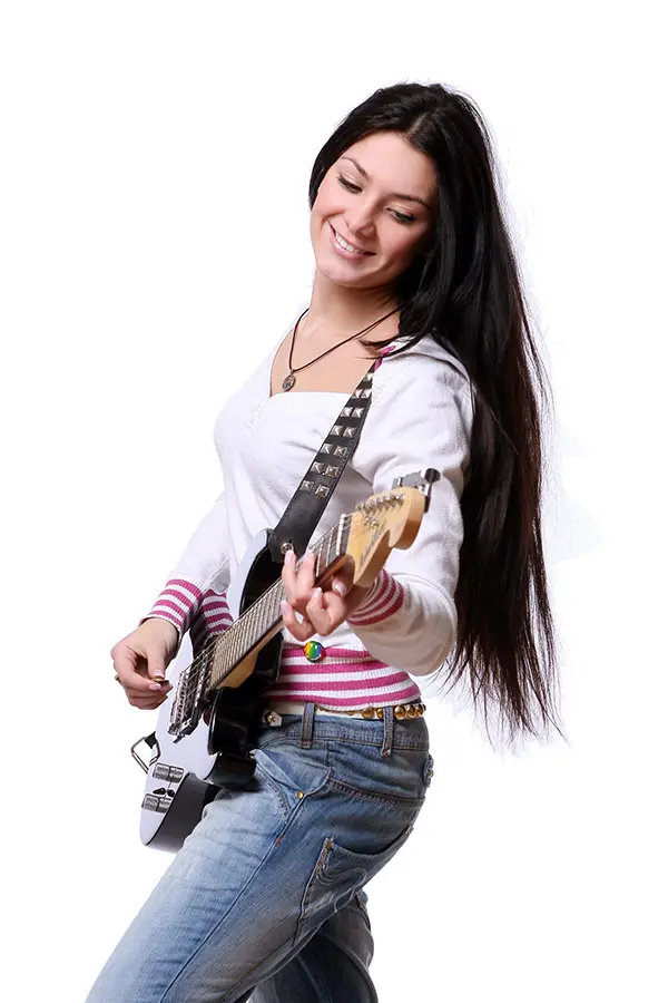 Smiling woman with long hair playing a white electric guitar