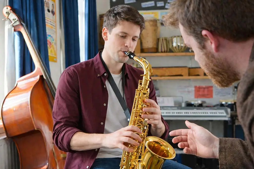 Teacher guiding a student playing alto saxophone
