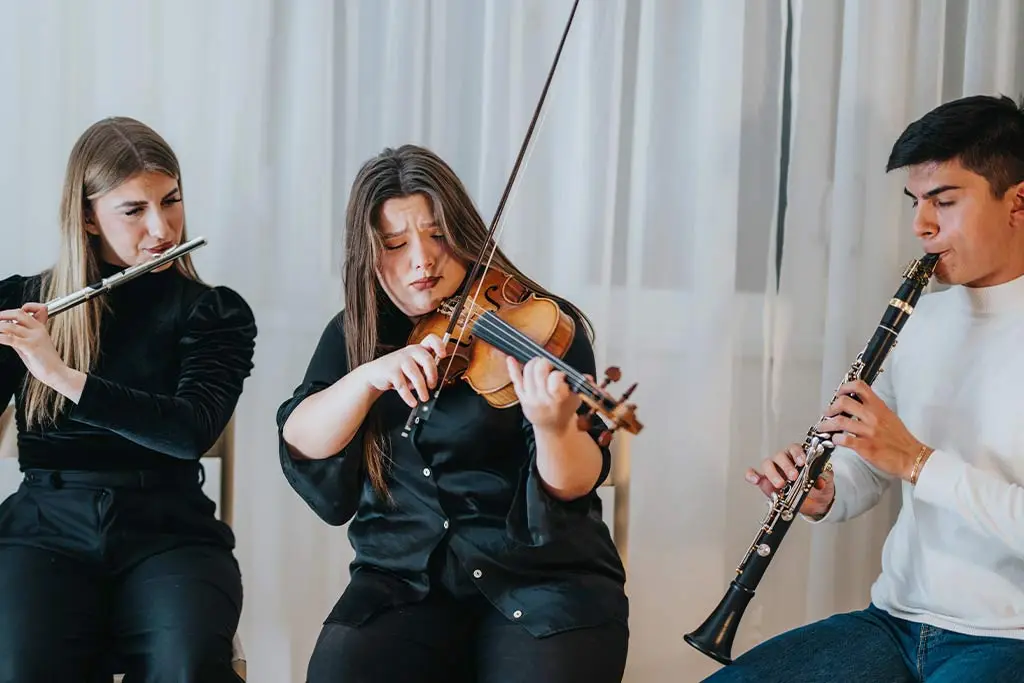 Three musicians playing violin and flute