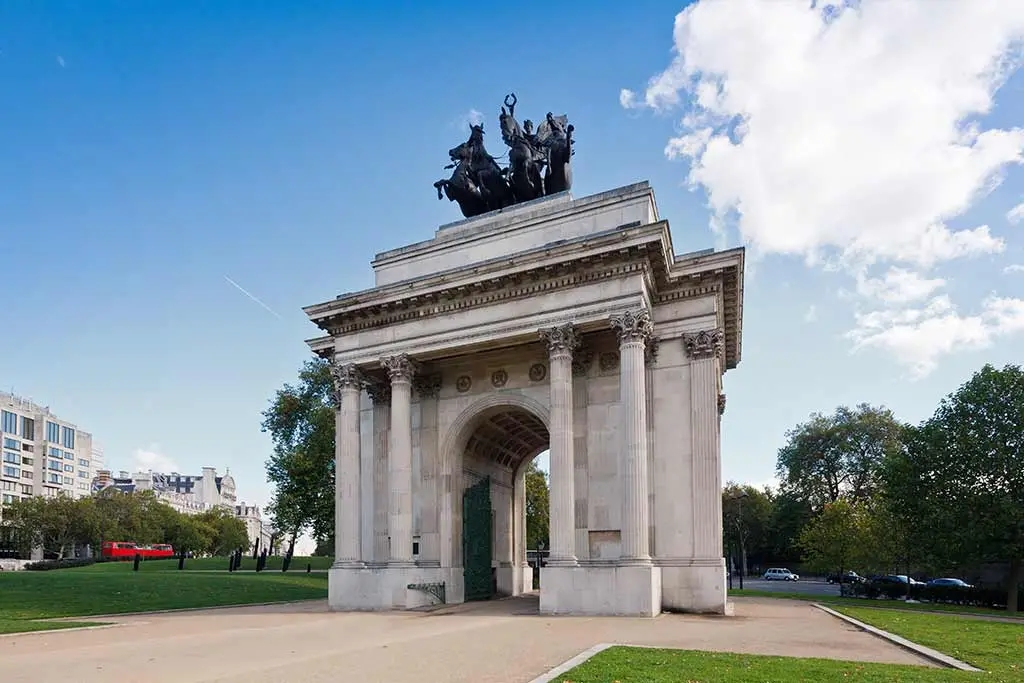 Wellington Arch with its quadriga sculpture beside green parkland
