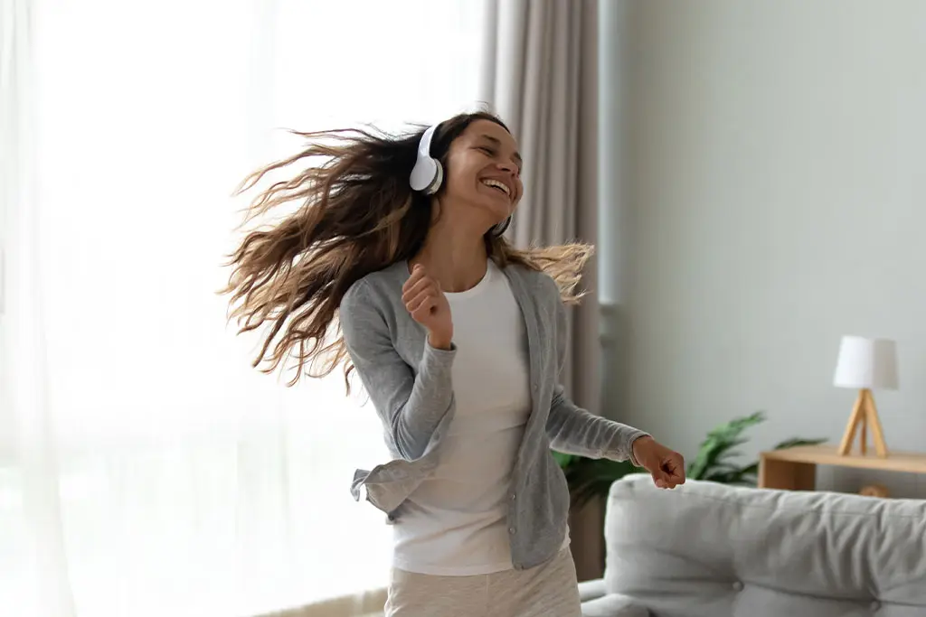 Woman dancing to music at home