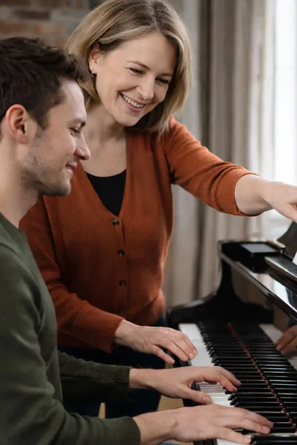 Woman guiding a man playing the piano