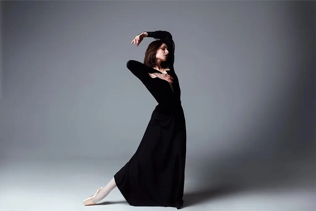Woman in a black dress holding a dance pose