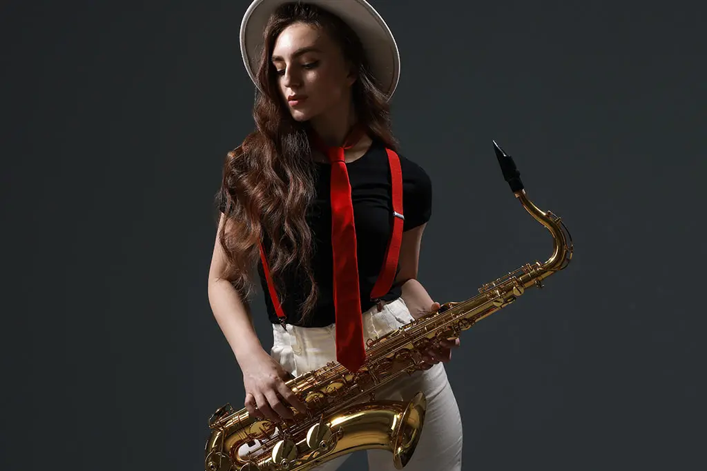 Woman in a hat holding a tenor saxophone