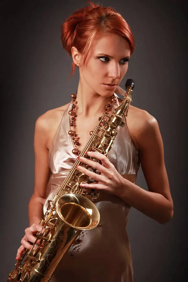 Woman in red hair holding saxophone