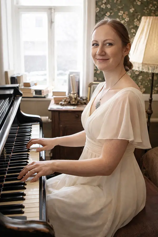 Woman in a white dress playing a piano