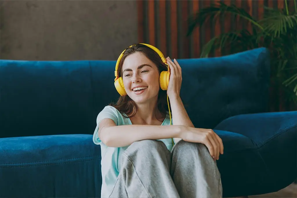 Woman sitting with headphones on listening to music