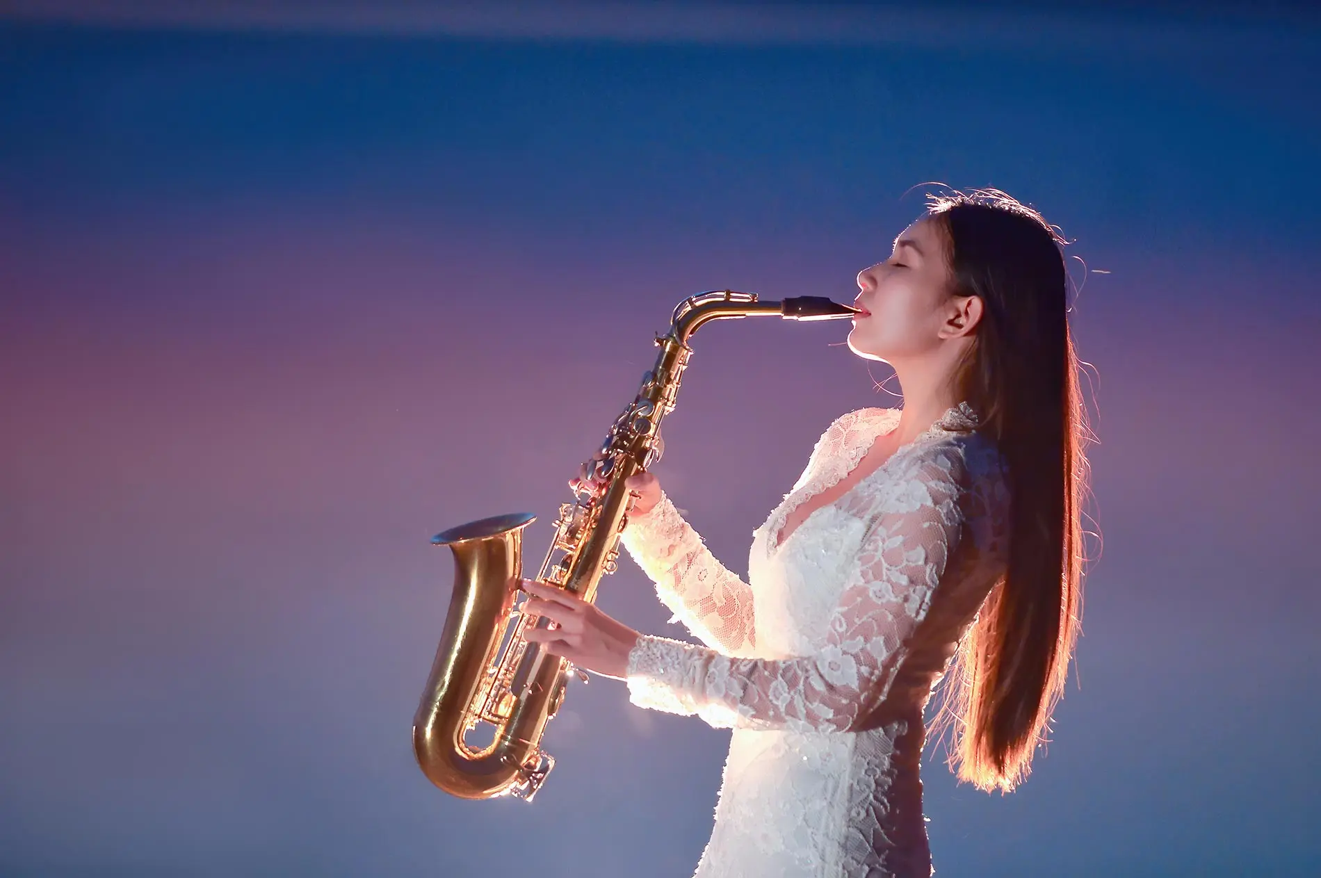 Asian woman with white dress playing saxophone passionately