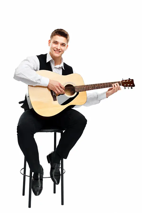 Young man seated on a stool holding an acoustic guitar