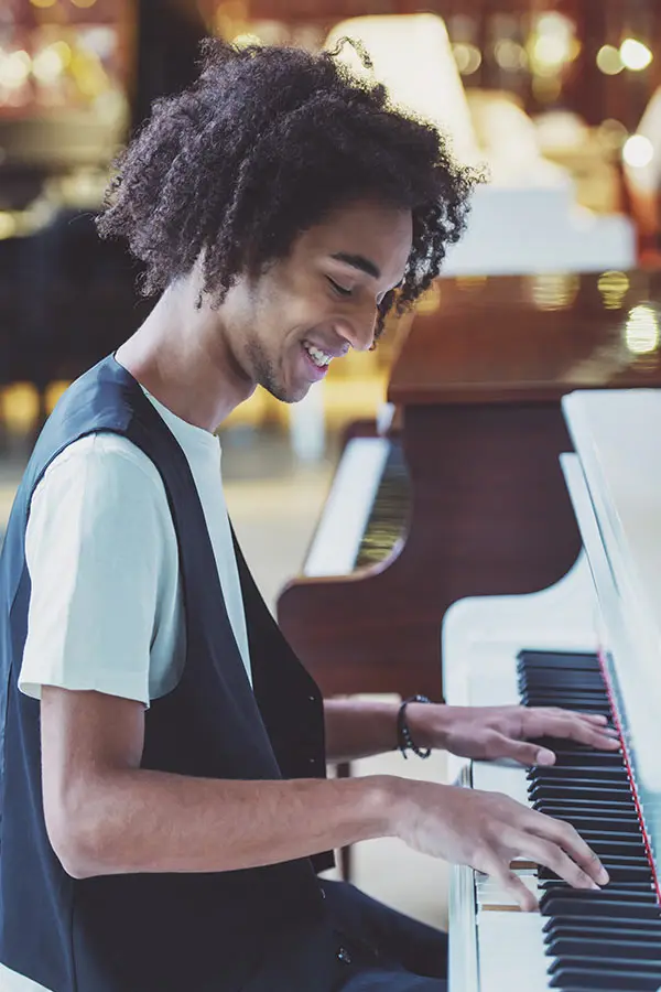 Young man smiling while playing the piano