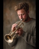 A bearded man playing the trumpet
