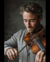 A bearded man playing the viola
