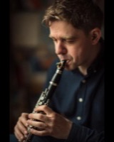 Man playing the clarinet with his eyes closed