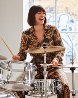 Woman playing the drums in a sunlit studio